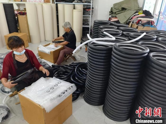 圖為村民在汽車飾品企業(yè)生產(chǎn)車間中工作。　呂子豪 攝