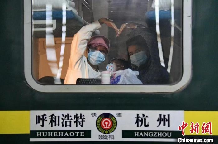 圖為登上轉(zhuǎn)運火車的游客向額濟(jì)納比心?！⊥趵?攝