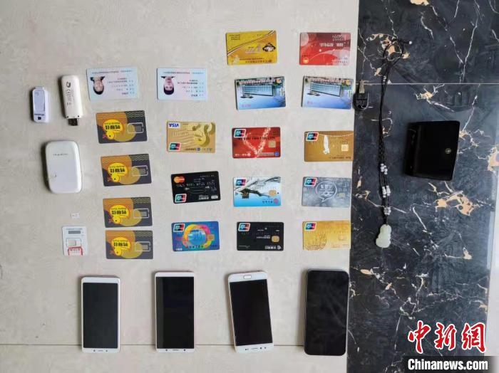 資料圖為果洛藏族自治州公安民警查扣的作案手機(jī)和涉案銀行卡?！‖斍呖h公安局供圖