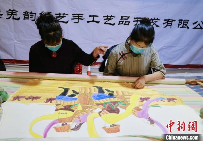 圖為皮繡藝人在市集上“秀”指尖技藝。　馬銘言 攝