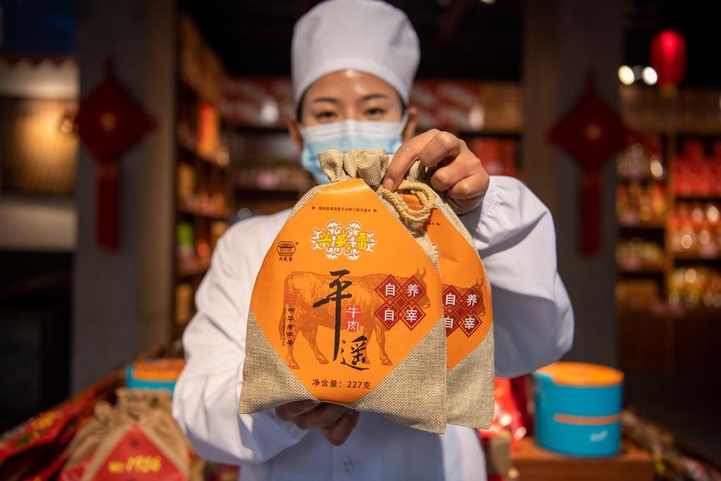 1月27日，在平遙古城南大街的一家平遙牛肉店內(nèi)，工作人員展示一款牛肉產(chǎn)品。新華社記者 楊晨光 攝