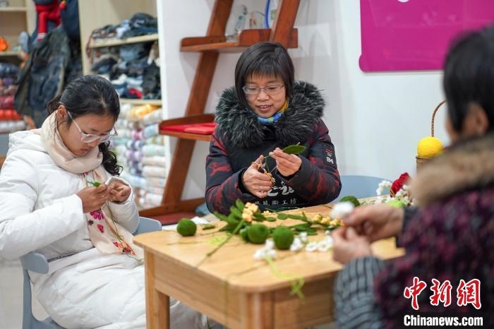 文創(chuàng)工作室的姐妹們正在鉤織月桂葉片。　古良駒 攝