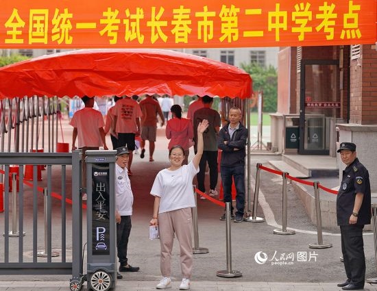 6月7日，在長春市第二中學(xué)考點，一名考生信心滿滿進入考場，并與家長揮手致意。人民網(wǎng)記者 李洋攝