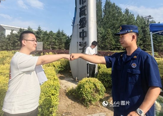 6月7日，遼寧營口老邊區(qū)消防救援大隊的消防員為高考學(xué)子加油助威。人民網(wǎng)記者 尹柏寒?dāng)z