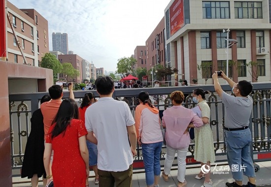 6月7日，武漢市第三中學(xué)考點，考生進場后，家長在柵欄外用手機拍攝自己的孩子。人民網(wǎng)記者 郭婷婷攝
