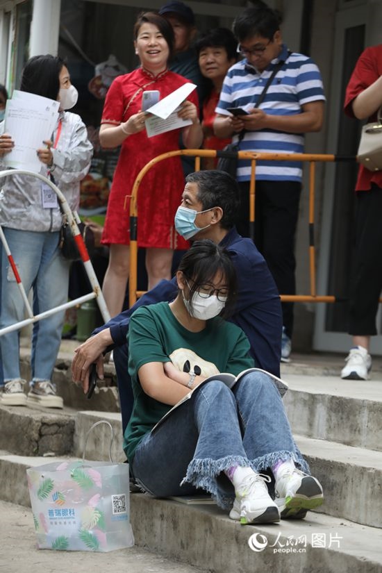 6月7日，沈陽市第一中學(xué)，學(xué)子靠在父親身邊做最后的沖刺。人民網(wǎng) 周頌雪攝