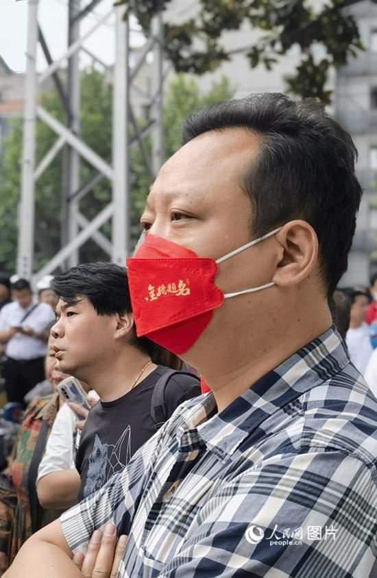 6月7日早，在武漢市第二十六中學(xué)考點外，送考家長戴著印有“金榜題名”的口罩。人民網(wǎng) 周雯攝