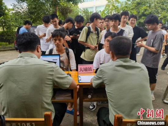 專武干部在發(fā)放兵役登記證。韋碩 攝
