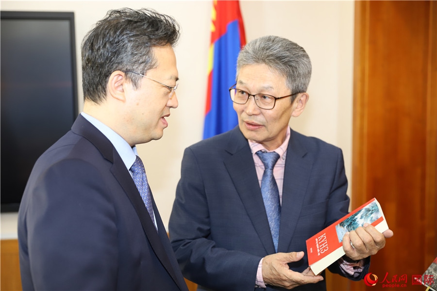 其米德策耶（右一）向李峙介紹翻譯成果。人民網(wǎng)記者 霍文攝