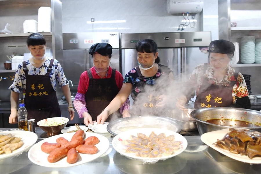 福建三明市沙縣區(qū)一家小吃店工作人員在為客人準(zhǔn)備特色小吃。 新華社記者 林善傳 攝