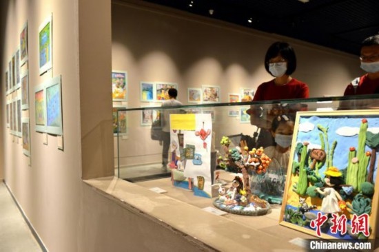 圖為家長(zhǎng)帶著孩子參觀展覽。呂明 攝