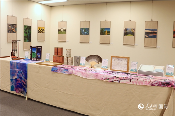 現(xiàn)場展出的馮學敏攝影作品與湖州市特色工藝品。（人民網(wǎng) 許可攝）