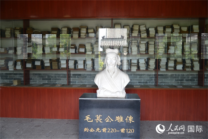 河間詩(shī)經(jīng)齋毛萇雕像。雕像后書櫥中陳列的是歷代各版本《詩(shī)經(jīng)》及譯本。 人民網(wǎng) 趙昭攝