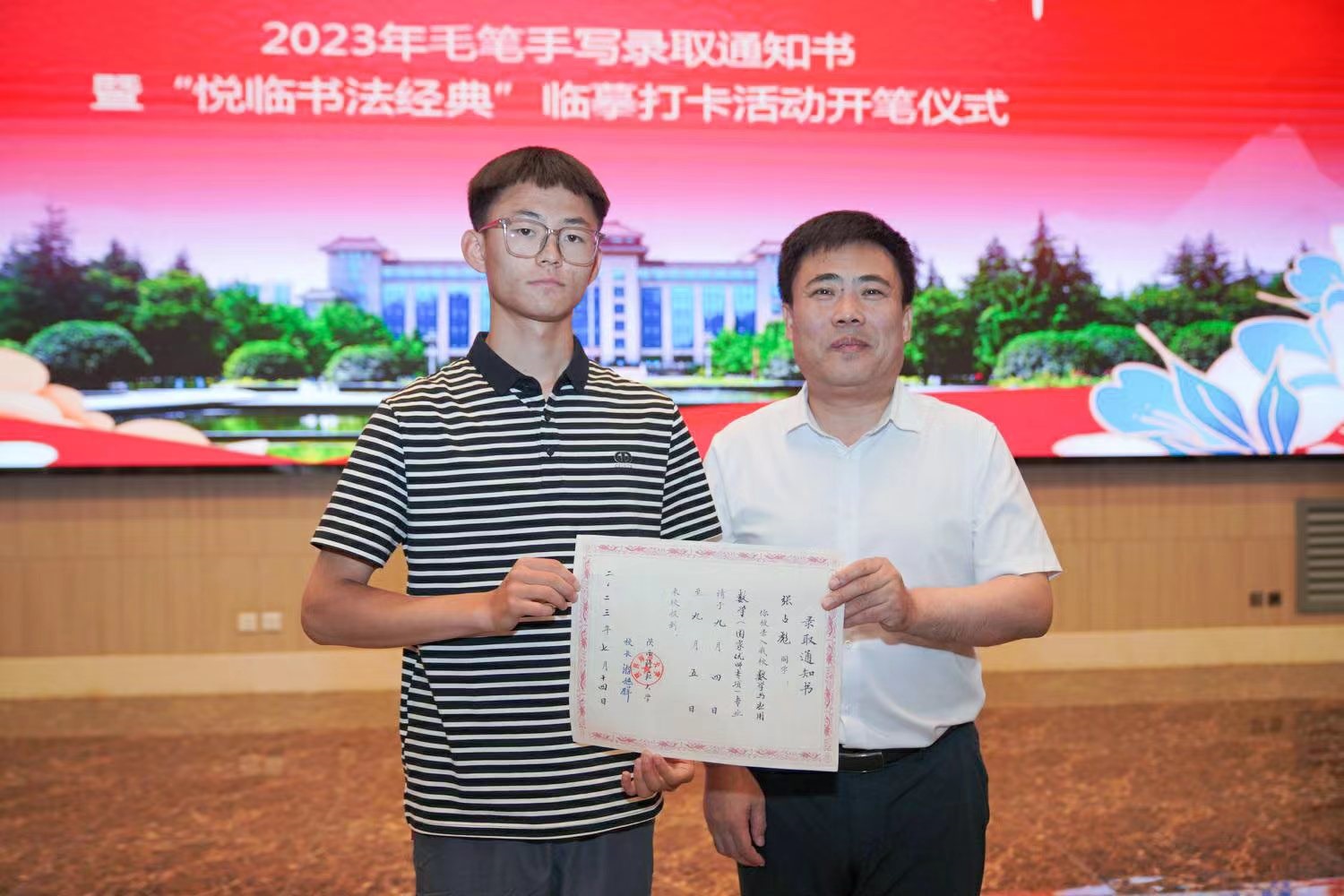 陜西師范大學(xué)黨委書(shū)記李忠軍為2023級(jí)新生代表張占彪同學(xué)發(fā)放錄取通知書(shū)。校方供圖