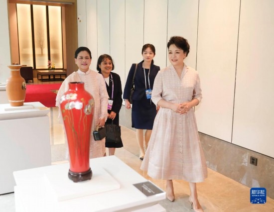 7月27日下午，國(guó)家主席習(xí)近平夫人彭麗媛在四川成都會(huì)見陪同印度尼西亞總統(tǒng)佐科來華出席第31屆世界大學(xué)生夏季運(yùn)動(dòng)會(huì)開幕式并訪華的總統(tǒng)夫人伊莉亞娜。這是彭麗媛和伊莉亞娜欣賞成都特色非遺工藝品。新華社記者 丁林 攝