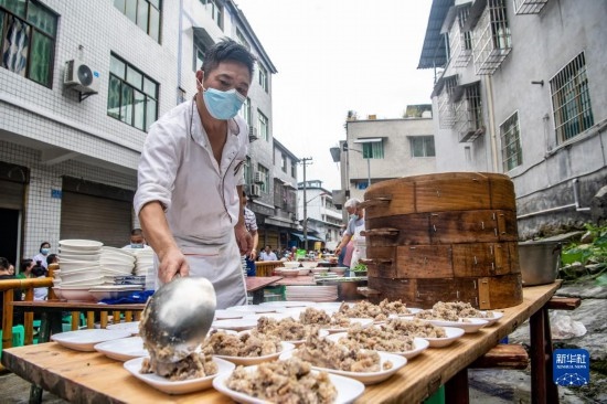 7月29日，在重慶市綦江區(qū)安穩(wěn)鎮(zhèn)，當?shù)鼐用裨凇懊缂曳蚬?jié)”上準備羊肉長桌宴。新華社記者 唐奕 攝