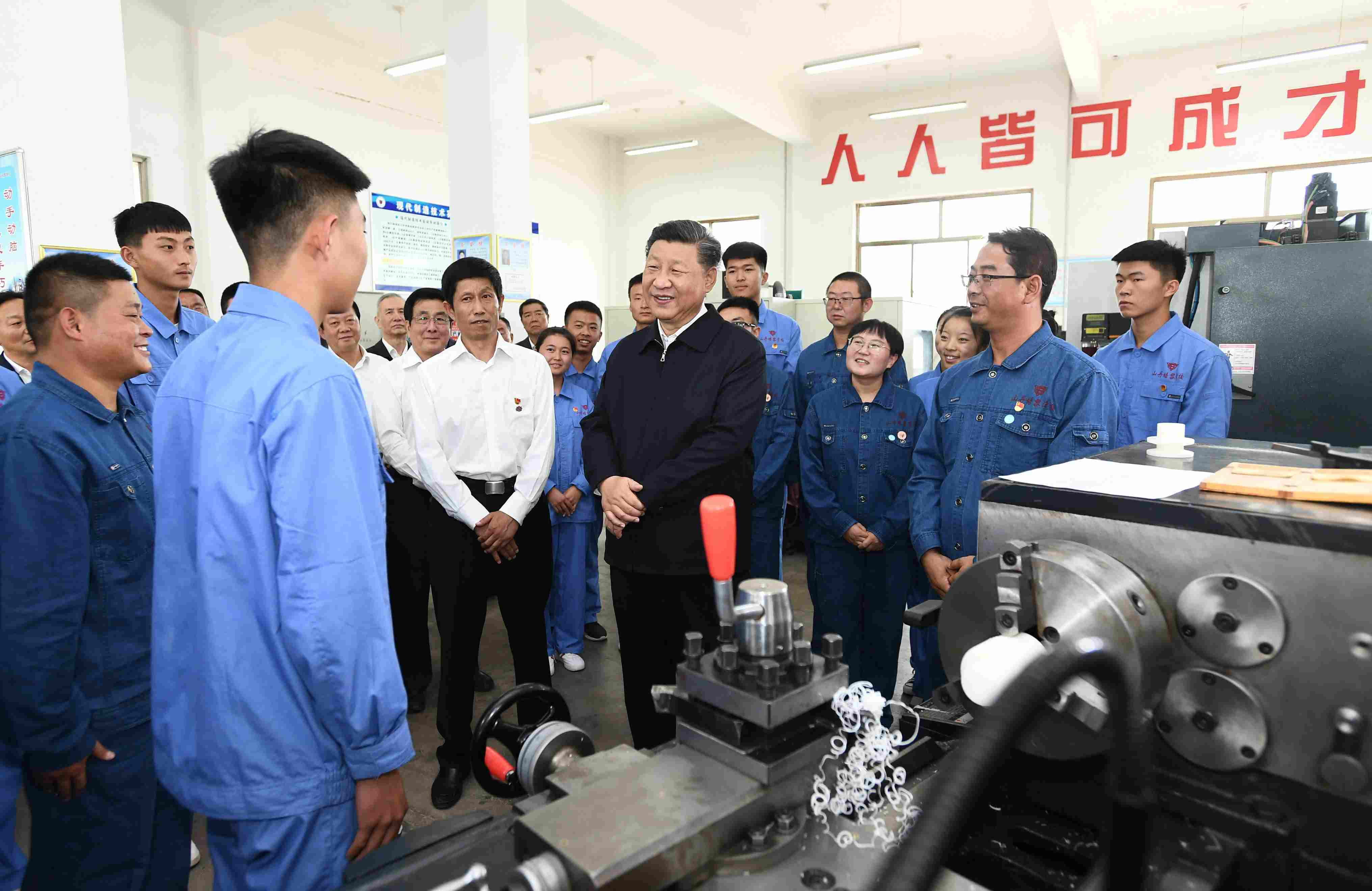 2019年8月20日，習(xí)近平在甘肅省張掖市山丹培黎學(xué)?，F(xiàn)代制造技術(shù)實(shí)訓(xùn)室，觀看職業(yè)技能實(shí)訓(xùn)，同師生親切交流。