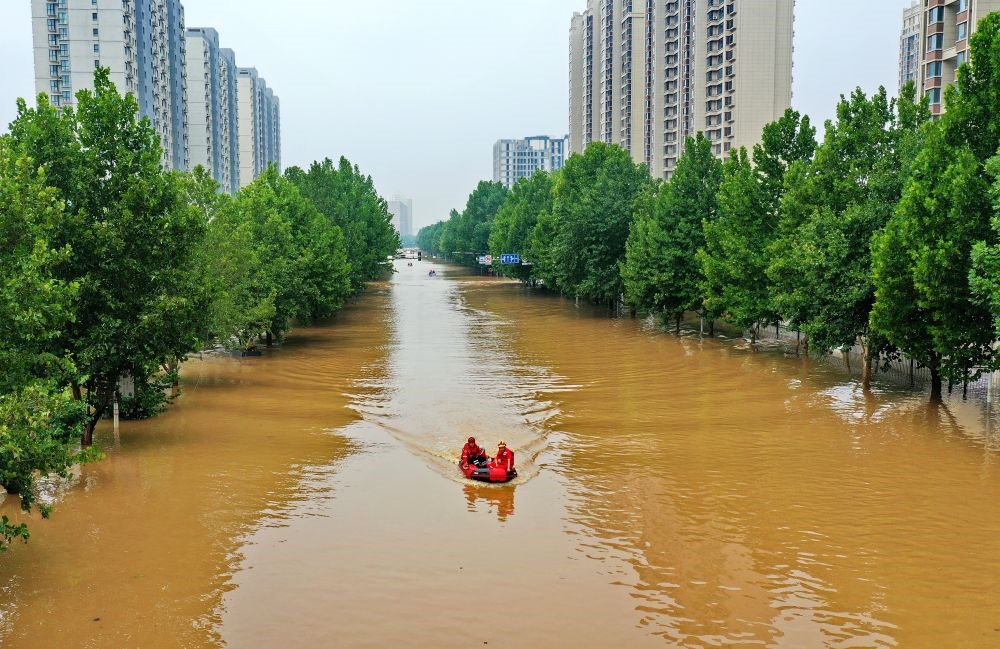 救援人員在河北省涿州市市區(qū)乘坐沖鋒舟前去轉(zhuǎn)移受災群眾（8月2日攝，無人機照片）。新華社記者 牟宇 攝