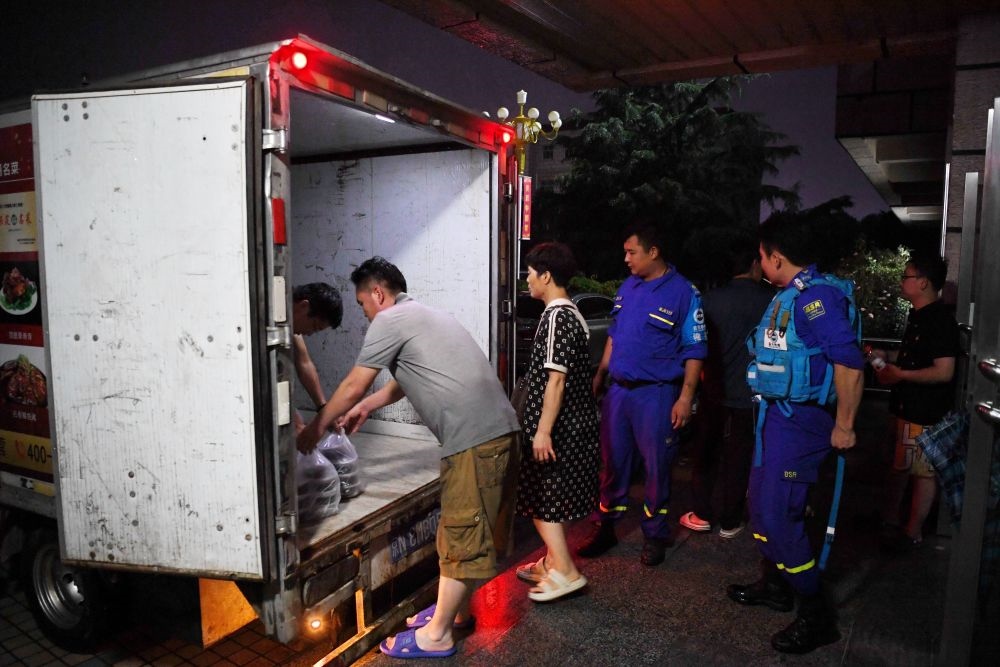 河北省涿州市職教中心安置點的工作人員在運送飯菜，準備發(fā)放給安置群眾（8月1日攝）。新華社記者 牟宇 攝