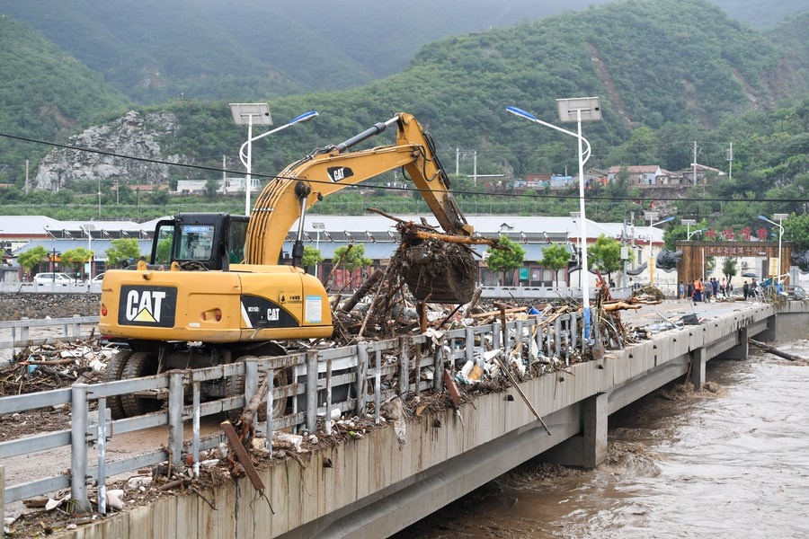 8月1日，在北京市門(mén)頭溝區(qū)水峪嘴村村口，一臺(tái)挖掘機(jī)在清理阻斷橋梁交通的雜物。目前該條道路已經(jīng)疏通完成。新華社記者 鞠煥宗 攝