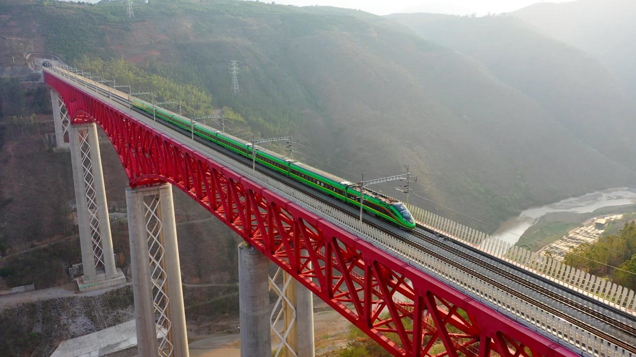 中老鐵路國際旅客列車在云南省境內(nèi)的元江特大橋上飛馳。姚巍攝