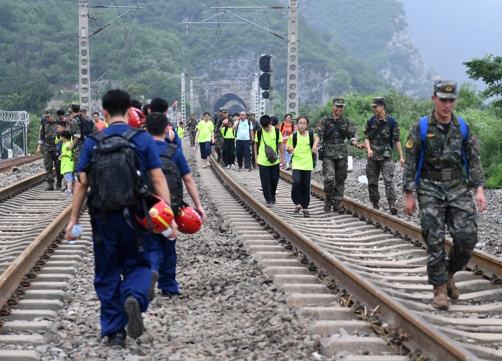 8月2日，部分滯留在北京市門頭溝山區(qū)受困列車的旅客，在救援人員幫助下前往轉運客車。新華社記者張晨霖 攝