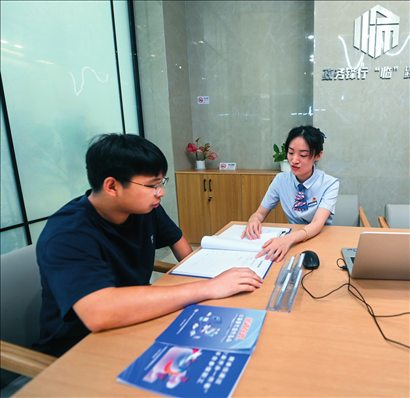 在杭州市臨安區(qū)政務(wù)服務(wù)中心的“為企服務(wù)中心”，黨員志愿者（右）解答企業(yè)主的疑問(wèn)（2023年7月7日攝）。徐昱攝/本刊