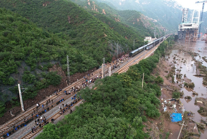 8月2日，受困列車旅客在救援人員幫助下徒步趕往轉運客車（無人機照片）。新華社記者 張晨霖 攝