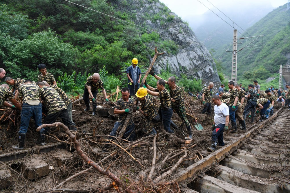 8月1日，在北京市門頭溝區(qū)水峪嘴村附近一段被阻斷的鐵路線上，中鐵六局工作人員在清理軌道上的雜物，全力恢復交通。新華社記者 鞠煥宗 攝