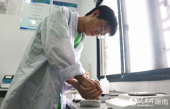 吳健筆在獼猴桃科技小院實(shí)驗(yàn)室測(cè)量水果糖分。 人民網(wǎng)記者 劉賓攝