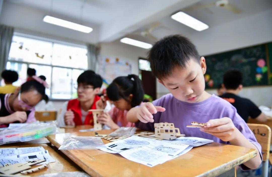 △今年7月，在浙江余姚市舜北小學暑托班內(nèi)，孩子們制作太陽能科學實驗裝置。
