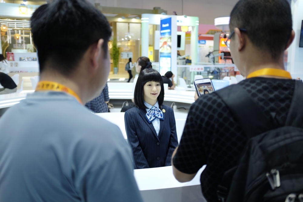 9月1日，媒體記者在國家會議中心與服務機器人互動。新華社記者 劉夢琪 攝