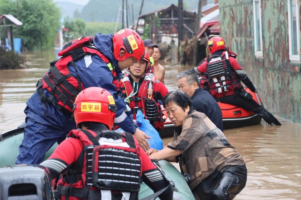 8月4日，在黑龍江省尚志市一面坡鎮(zhèn)萬(wàn)山村，哈爾濱市森林消防支隊(duì)的消防員在解救被困村民。新華社發(fā)