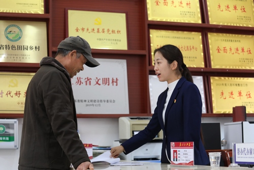 李敏在雙蕩村便民服務(wù)大廳接待前來(lái)辦理業(yè)務(wù)的村民。受訪者供圖