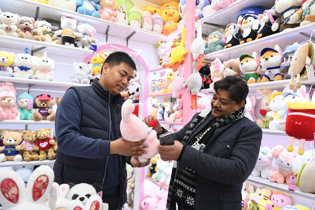 2023年2月2日，來(lái)自印度的客商（右）在義烏國(guó)際商貿(mào)城的一家玩具店鋪內(nèi)選購(gòu)商品。新華社記者 黃宗治 攝