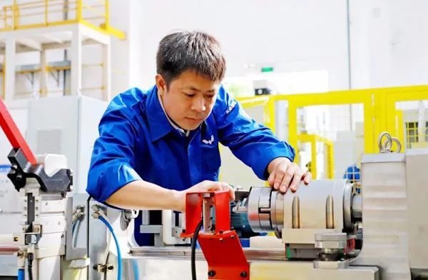△鄭志明正在對襯套自動壓裝設備進行檢測調(diào)試。