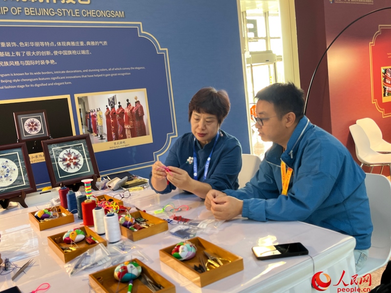 記者在新聞中心非遺傳承人展區(qū)進行體驗。人民網(wǎng)記者 杜燕飛攝