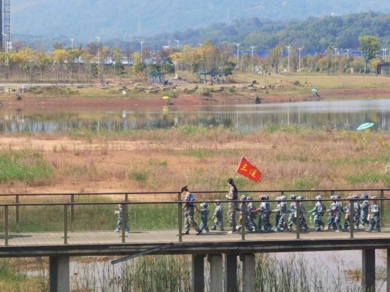 10月24日，秋游的幼兒園小朋友在老師帶領(lǐng)下走在清水塘公園里的木橋上。本報記者 常雯宜攝
