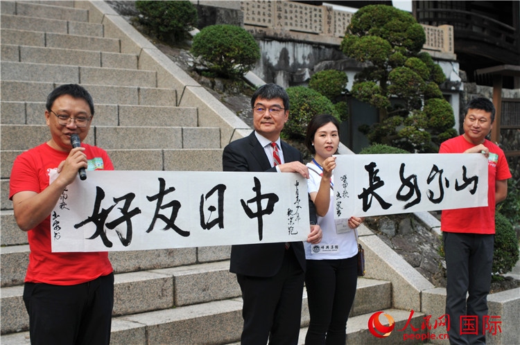 東京中國(guó)文化中心主任羅玉泉展示其為本次活動(dòng)書(shū)寫(xiě)的題詞“中日友好，山高水長(zhǎng)”。人民網(wǎng) 蔣曉辰攝