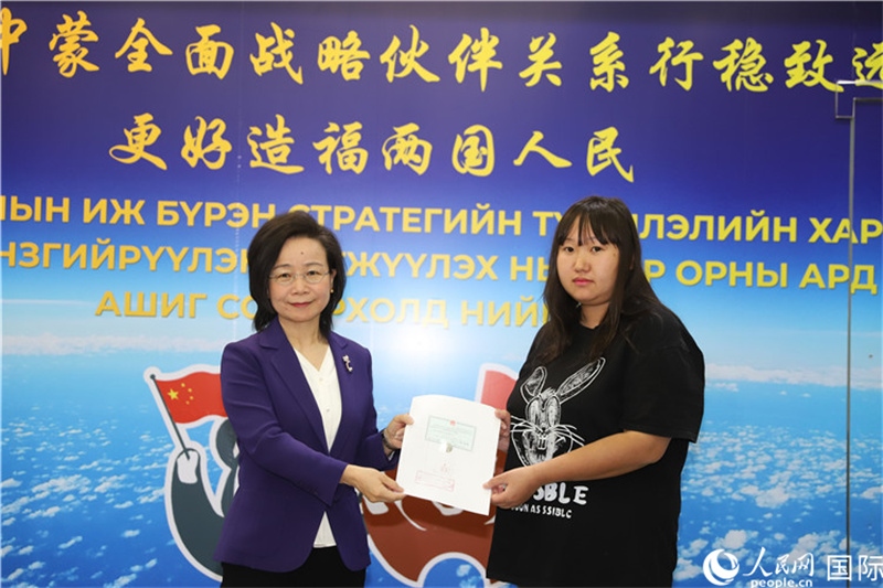 11月10日，沈敏娟大使向蒙古國(guó)公民尼亞姆庫(kù)（右）頒發(fā)最后一份領(lǐng)事認(rèn)證書。人民網(wǎng)記者 霍文攝