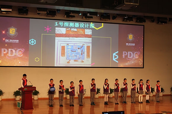 北京呼家樓中心小學的學生們展示PDC項目“新行星移民計劃探索衛(wèi)星設計”。