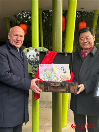 吳墾大使和韋格納市長手捧德國兒童為“夢(mèng)想”“夢(mèng)圓”準(zhǔn)備的手繪“送別大禮包”。人民網(wǎng)記者 徐馨攝