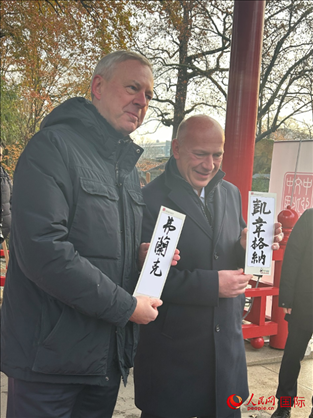 柏林市長韋格納（右）、動(dòng)物園監(jiān)事會(huì)主席布魯克曼（左）手持中國文化中心工作人員現(xiàn)場(chǎng)手書的中文名字。人民網(wǎng)記者 徐馨攝