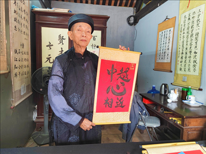 越南首都河內(nèi)文廟內(nèi)，阮明珠展示“中越心相近”書法作品。