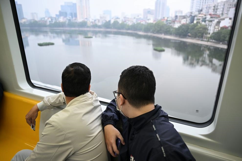 12月9日，市民在越南河內(nèi)輕軌二號線車廂內(nèi)透過車窗欣賞城市風(fēng)景。