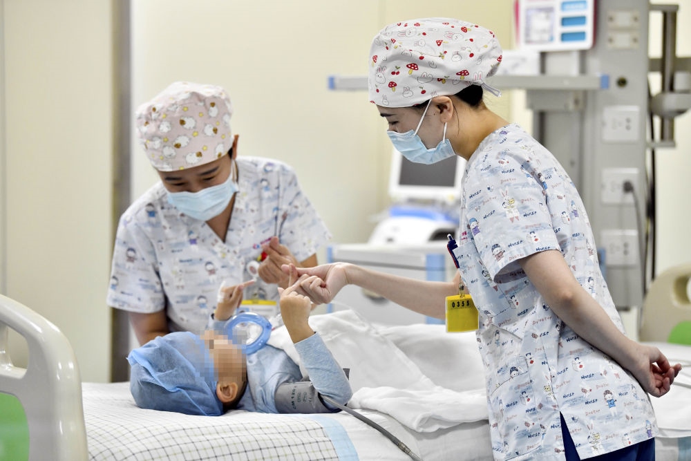 在山東省棗莊市婦幼保健院兒童ICU病房，醫(yī)護(hù)人員為完成靶向治療藥物諾西那生鈉的4歲脊髓性肌萎縮癥患兒加油鼓勁（2022年1月1日攝）。諾西那生鈉注射液是我國首個(gè)獲批治療脊髓性肌萎縮癥的進(jìn)口藥物，2019年進(jìn)入中國市場(chǎng)時(shí)，每針價(jià)格近70萬元。在2021年國家醫(yī)保目錄藥品談判中，以3.3萬元每針的價(jià)格進(jìn)入新版醫(yī)保藥品目錄。新華社記者 郭緒雷 攝