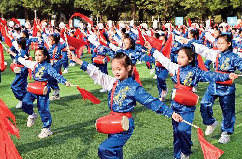 為助推民族地區(qū)基礎(chǔ)教育事業(yè)發(fā)展，廣西重新核定各地中小學(xué)教職工編制，依托全區(qū)編制“周轉(zhuǎn)池”核增事業(yè)編制給各地中小學(xué)，在全面達(dá)到國(guó)家標(biāo)準(zhǔn)的基礎(chǔ)上，進(jìn)一步統(tǒng)籌優(yōu)化和動(dòng)態(tài)調(diào)整各區(qū)域、學(xué)校、學(xué)段間編制資源。圖為2023年11月29日，南寧市濱湖路小學(xué)舉行主題為“逐夢(mèng)新時(shí)代 健體向未來(lái)”的體育文化節(jié)，孩子們正在跳腰鼓舞。 新華社記者 周華/攝