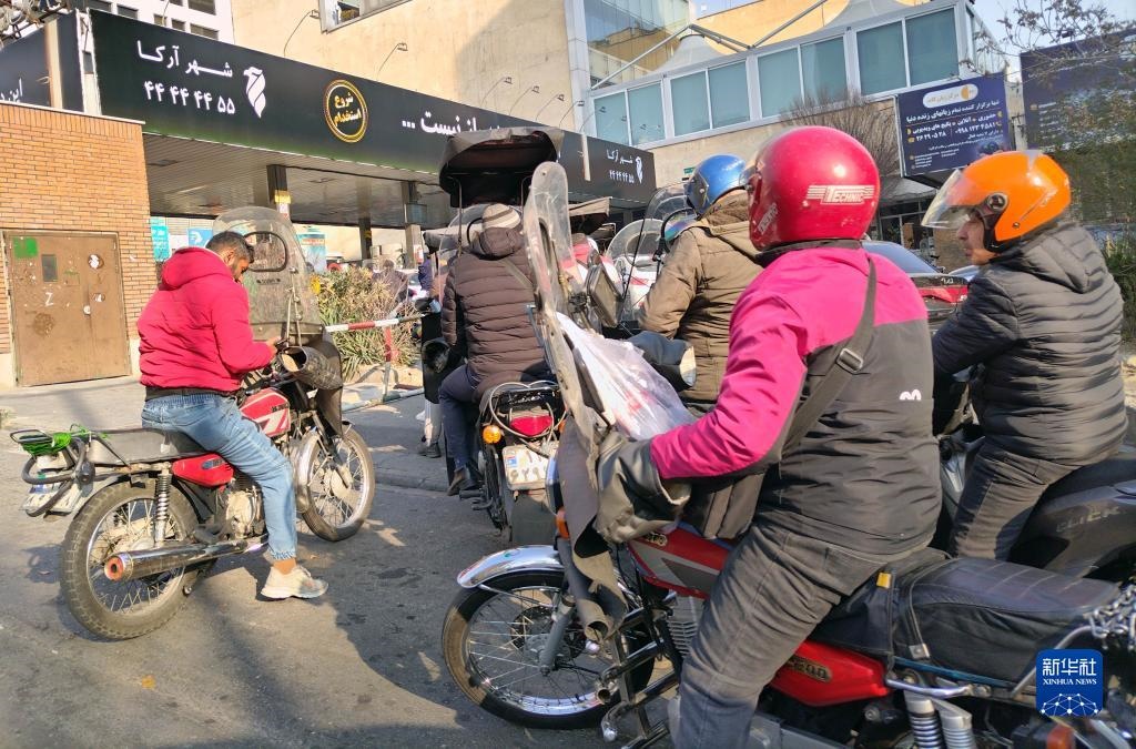 12月18日，摩托車在伊朗首都德黑蘭的一家加油站外等待加油。新華社記者 沙達(dá)提 攝