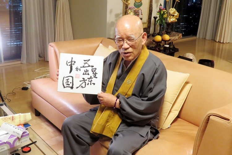 小島康譽(yù)展示自己書(shū)寫(xiě)的“五星出東方利中國(guó)”。視頻截圖
