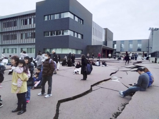  1月1日，在日本石川縣輪島市，人們站在被地震破壞的地面上。新華社/共同社